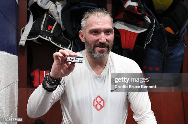Alex Ovechkin of the Washington Capitals holds the puck from his 894th career goal scored in the locker room after defeating the Chicago Blackhawks...