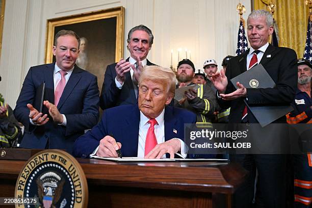 President Donald Trump signs an executive order to boost coal mining and production in the United States, in the East Room of the White House on...
