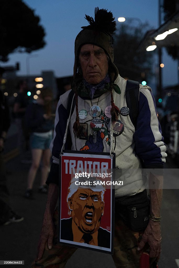 Middle Man Hand Off A man wears a sign depicting Donald Trump with the word 'TRAITOR ...