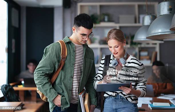studierende, die in einer modernen café-umgebung mit digitalen geräten zusammenarbeiten - hochschulstudium stock-fotos und bilder