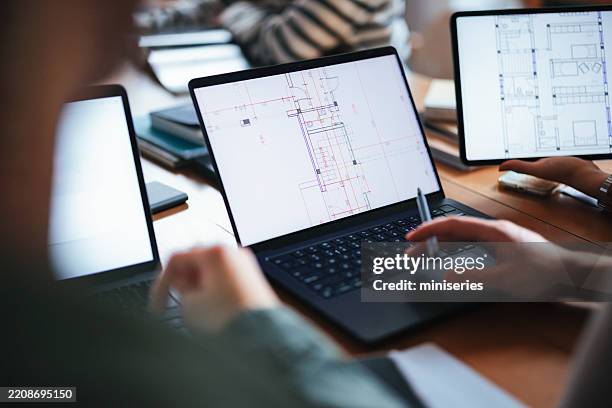 travail d’équipe collaboratif analyse des conceptions architecturales sur ordinateurs portables et tablettes - agence-de-design photos et images de collection