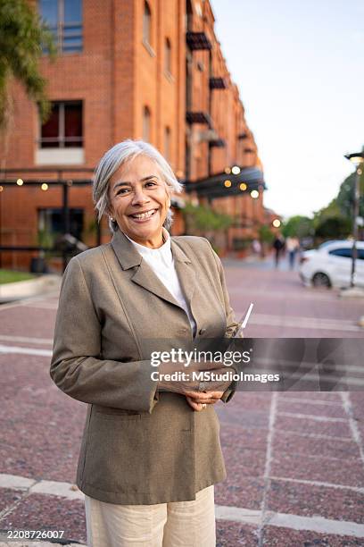 portrait of a confident professional woman standing outdoors in a business district location. looking at the camera - argentina stock pictures, royalty-free photos & images