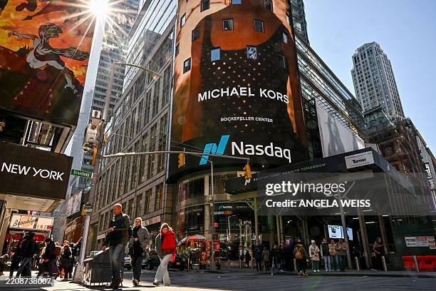People walk past the NASDAQ MarketSite in Times Square, New York City on April 9, 2025. Wall Street stocks were mixed in early trading Wednesday as...