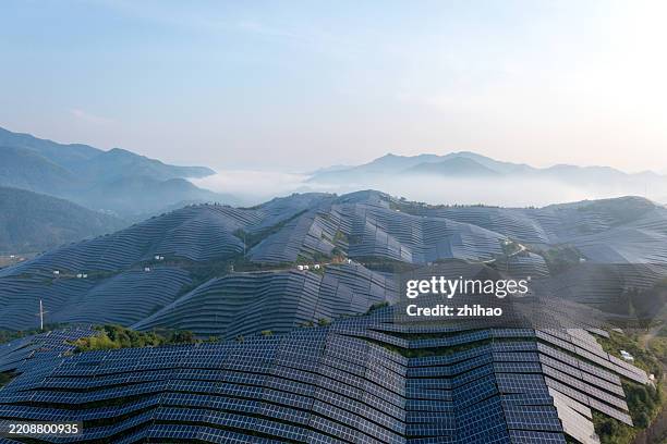 solar panels on mountain ridge at dawn - emissioni di co2 foto e immagini stock