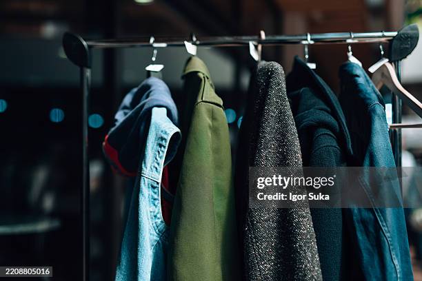 des vêtements durables suspendus sur un présentoir favorisant un consumérisme conscient - défilé photos et images de collection