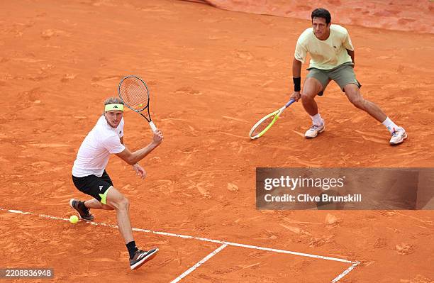 Alexander Zverev of Germany plays a backhand with Marcelo Melo of Brazil against Julian Cash and Lloyd Glasspool of Great Britain in the Men's...