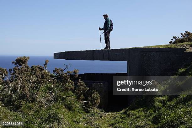 Man hikers look out to sea above the abandoned Spanish army bunker near Cape Prior..Located in the Rias Altas region, seen on APRIL 6 Ferrol,...