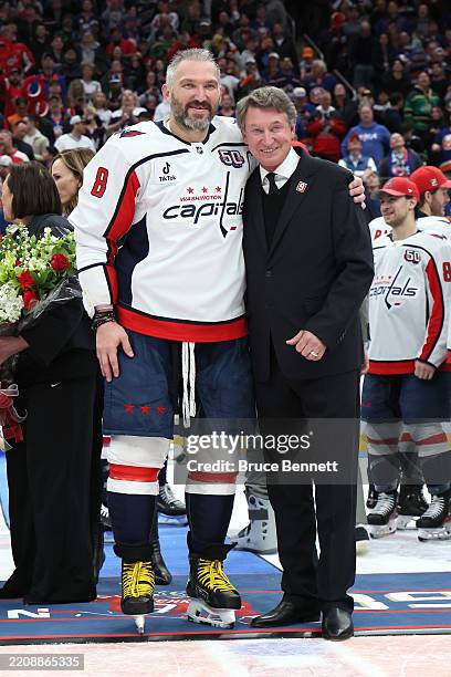 Alex Ovechkin of the Washington Capitals poses with former NHL player Wayne Gretzky after scoring his 895th career goal during the second period...