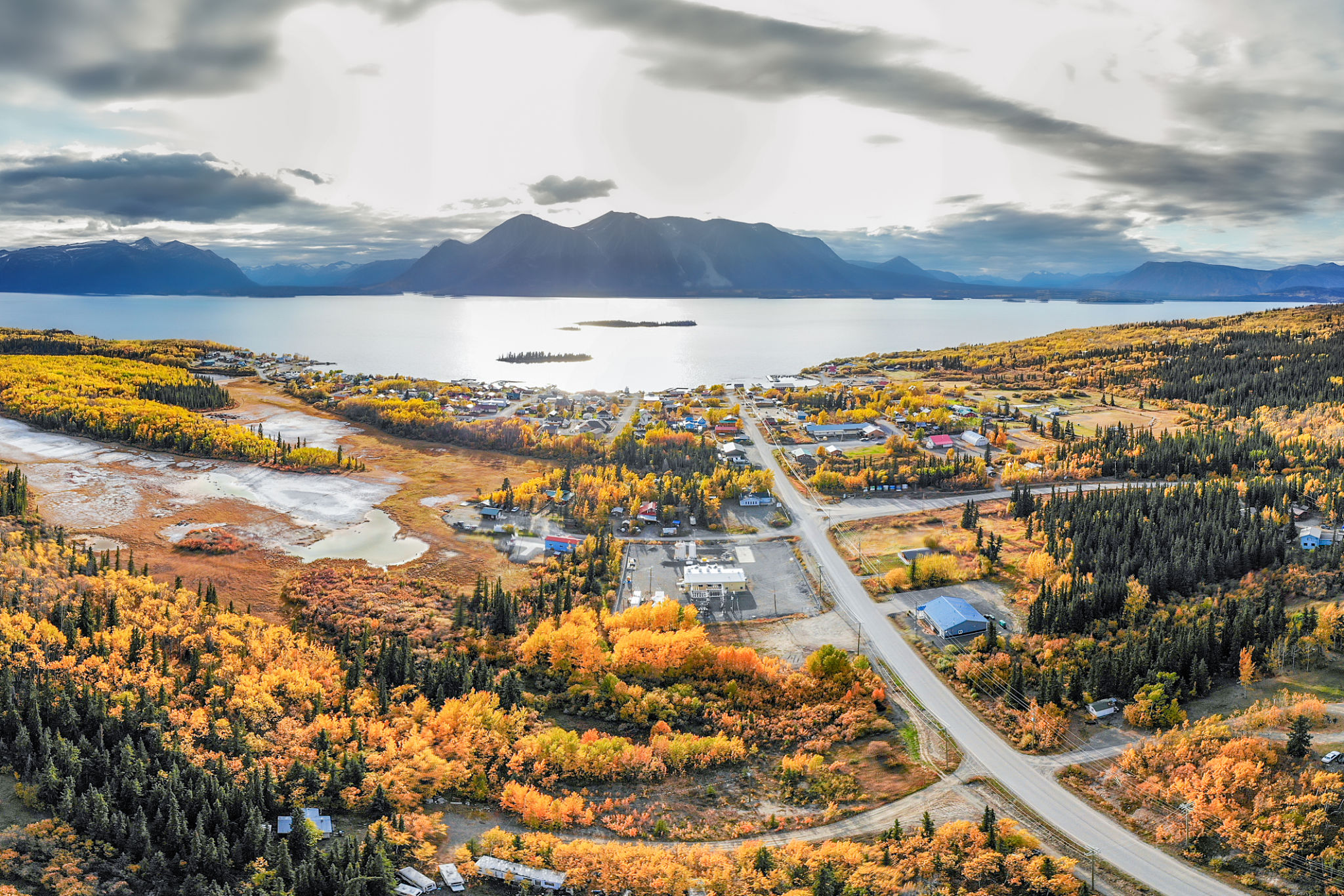 The small northern British Columbian town of Atlin near the Yukon Territory border. Taken by drone aerial shot in September during the peak fall autumn colors with yellow bright trees. The small northern British Columbian town of Atlin near the Yukon Territory border. Taken by drone aerial shot in September during the peak fall autumn colors with yellow bright trees.