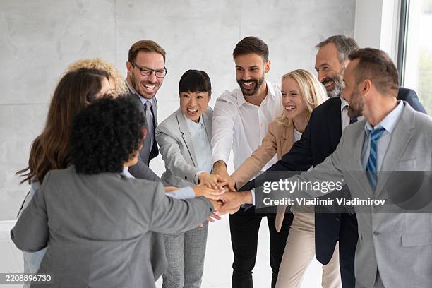 diverse group of professionals celebrating success together - hand stack stock pictures, royalty-free photos & images