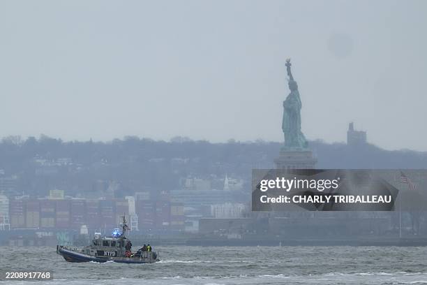 New York Police Department rescue boat is seen near the Statue of Liberty in New York after a helicopter crashed into the Hudson River on April 10,...