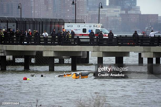 Police and firefighters work on the site after a helicopter crashed into the Hudson River near lower Manhattan, on April 10, 2025 in New York, United...