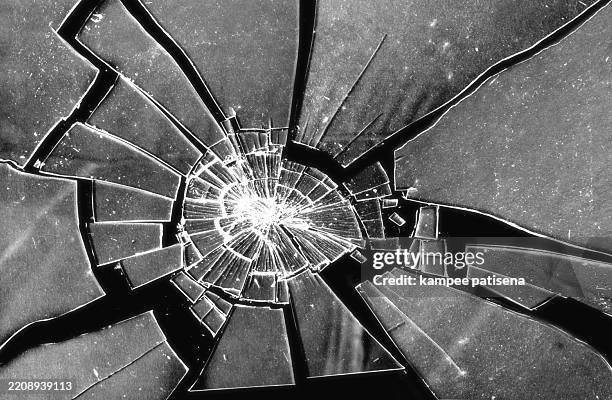 broken glass on black background shows the abstract texture of the shattered glass in great detail. the image is perfect for use in backgrounds, textures, or abstract art projects. - verre brisé photos et images de collection