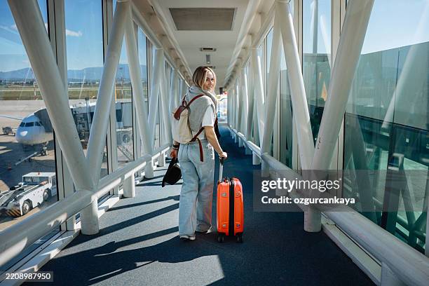young woman with cabin luggage - reisbestemmingen stockfoto's en -beelden