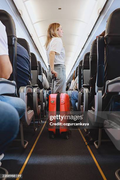 innenraum des flugzeugs mit menschen sitzen auf sitzen - flugzeugsitz stock-fotos und bilder