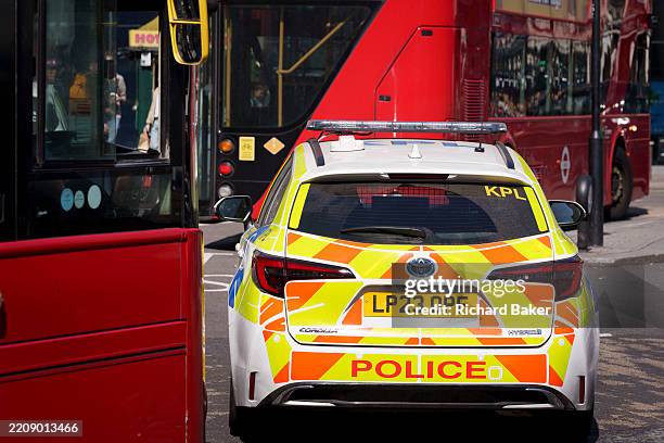 Met Police car is between London buses at Piccadilly Circus, on 10th April 2025, in London, England.