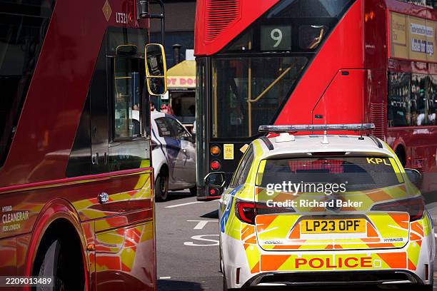 Met Police car is between London buses at Piccadilly Circus, on 10th April 2025, in London, England.