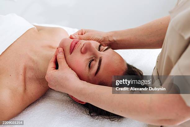 woman on spa procedure facial massage - massaggio del viso foto e immagini stock