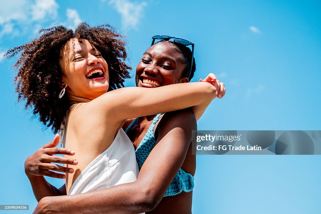 Happy young friends women embraced outdoors