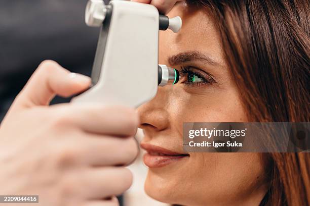 ophthalmologist examining patient's eye with modern equipment in clinic - profissional de oftalmologia imagens e fotografias de stock