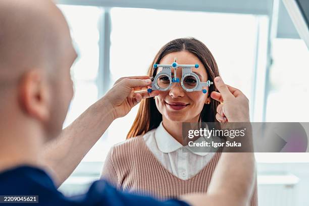 optometrist conducting vision test with patient using precision measurement device - ophthalmologist stock pictures, royalty-free photos & images