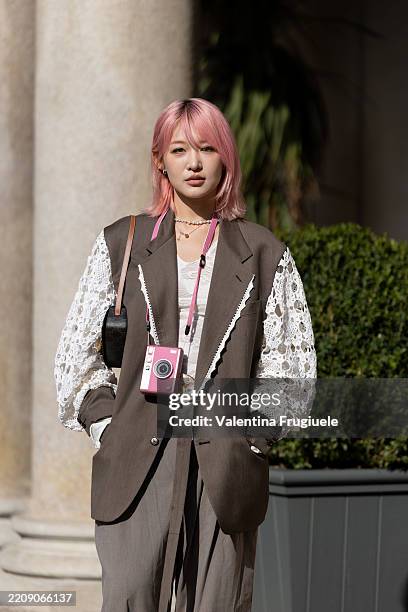 Passerby wears a beige cropped double-breasted trench jacket paired with high-waisted black pleated trousers during the Milan Design Week 2025 on...
