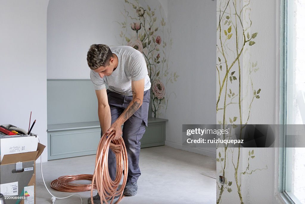 Man installing an air conditioner at a renovation project