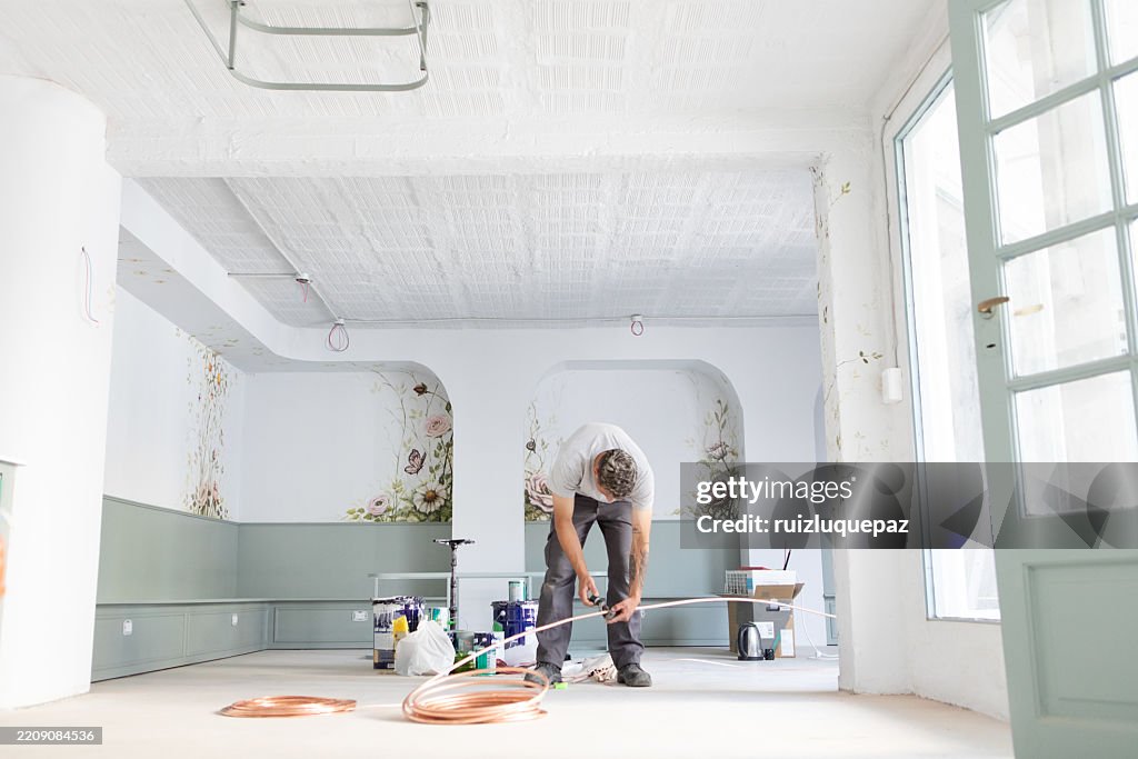 Man installing an air conditioner at a renovation project