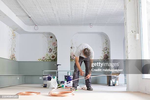 man installing an air conditioner at a renovation project - ductless air conditioner stock pictures, royalty-free photos & images