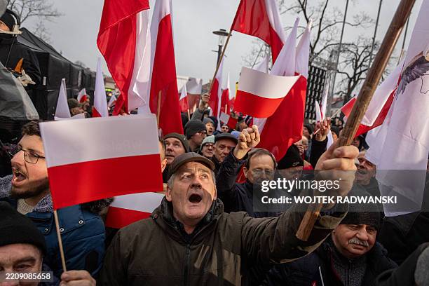Supporters of the right-wing candidate Karol Nawrocki wave flags on the main square of Konskie, central Poland on April 11, 2025 during tv debate...