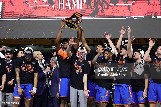 Rueben Chinyelu and head coach Todd Golden of the Florida Gators celebrate with the trophy after defeating the Houston Cougars in the National...