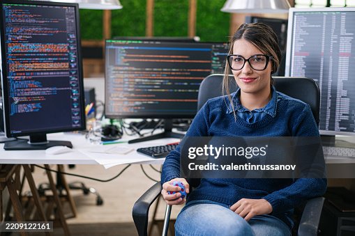 Female freelance developer coding and programming. Coding on two with screens with code language and application Female freelance developer coding and programming. Coding on two with screens with code language and application