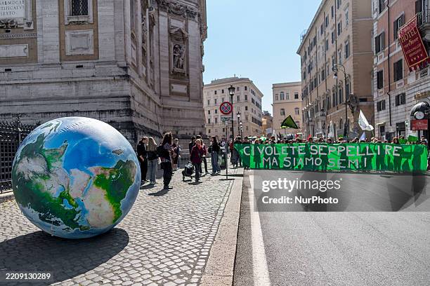 Climate activists rally to demand urgent action against the climate crisis, such as the redistribution of fossil fuel companies' excess profits,...
