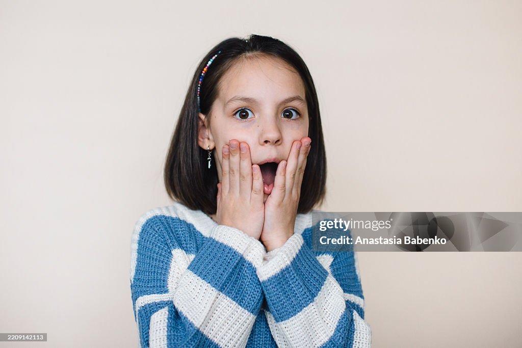 Studio Portrait Of Surprised Teenage Girl Looking At Camera High Res