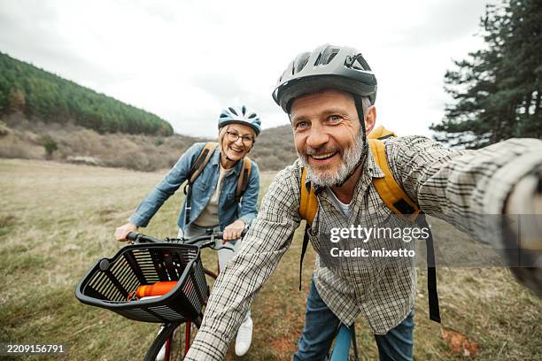pareja madura tomando selfie durante el descanso en bicicleta en el bosque - vida activa fotografías e imágenes de stock