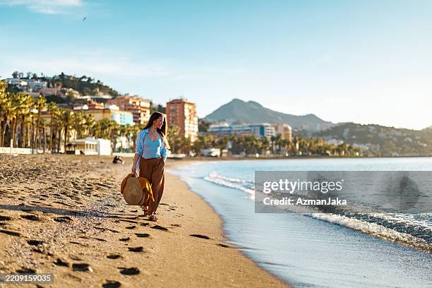 femme profitant d’une promenade tranquille sur la plage à malaga, espagne - malaga photos et images de collection