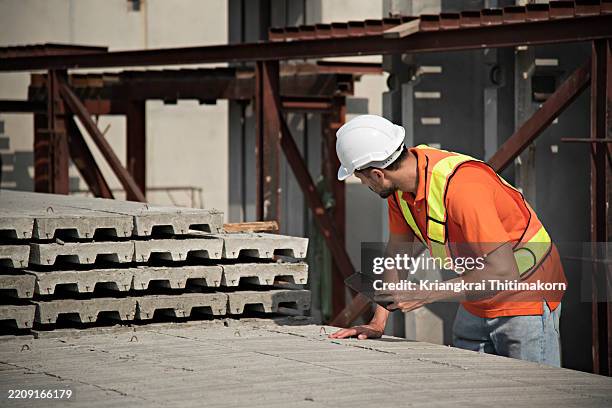 a construction worker is checking concrete broads using digital tablet outdoor. - construction material inspection stock pictures, royalty-free photos & images