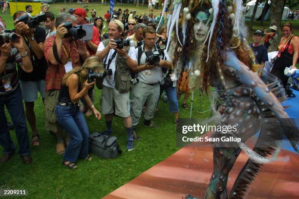 Photographers crowd around a model showing off the art on her body, painted to the theme of "Time Travel," at the European Body Painting Festival...