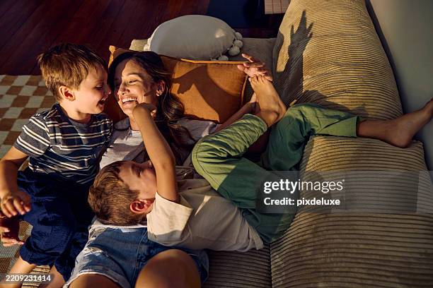 mother and children playing and laughing together on sofa at home - cosy stock pictures, royalty-free photos & images