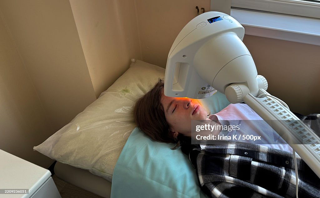 A teen undergoing infrared light therapy for an eye condition The