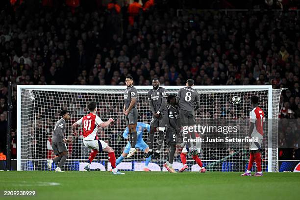 Declan Rice of Arsenal scores his team's first goal from a free kick as Jude Bellingham, Antonio Ruediger, Eduardo Camavinga and Federico Valverde of...
