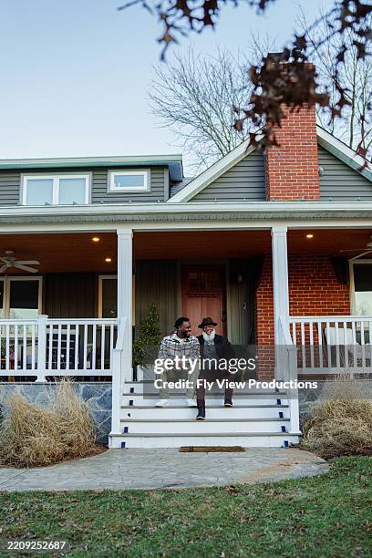 un homme âgé et son fils adulte discutent à l’extérieur à la maison - stéréotype de la classe moyenne photos et images de collection