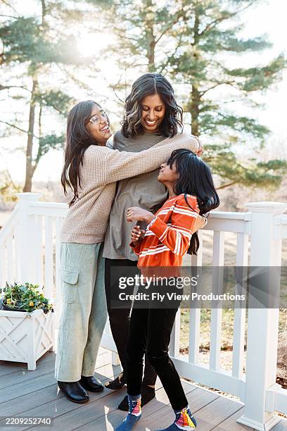 loving mom embracing her daughters - south asian people stock pictures, royalty-free photos & images