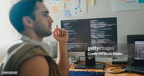 young gay computer programmer working on ai prompts and web page designs coding user experience on laptop in bedroom at home. software developer, artificial intelligence and programming. - programmer writing code stock pictures, royalty-free photos & images