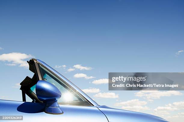 blue convertible sports car against sky - brand name sports car stockfoto's en -beelden