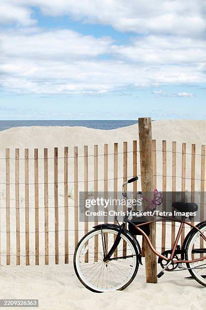 bicycle by fence on lavalette beach - fahrradschloss stock-fotos und bilder