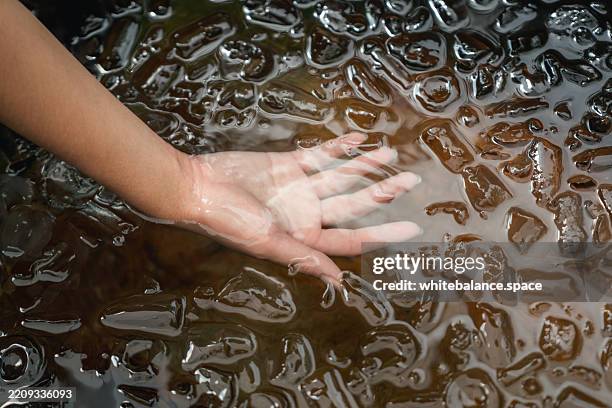 nahaufnahme von sanft in das eisige wasser eines eisbades gelegte foto während einer verjüngenden therapiesitzung - den sprung wagen stock-fotos und bilder