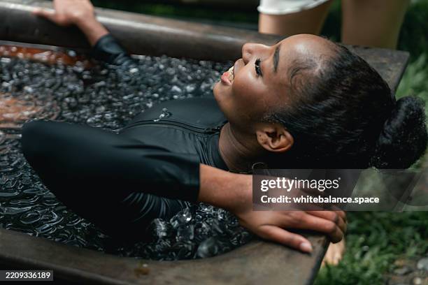 frauen, die die notwendigen schritte für die eisbadtherapie üben und sich mit den fingern die nase zukneifen, um den atem anzuhalten - den sprung wagen stock-fotos und bilder