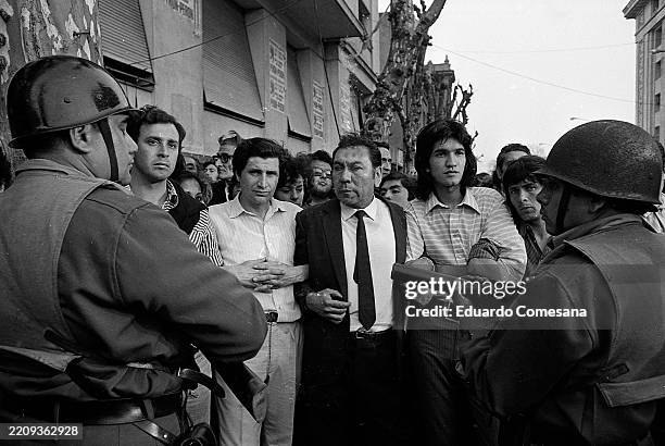View, from behind armed police officers, of mourners with linked arms outside the CGT union headquarters, on Calle Azopardo, during José Ignacio...