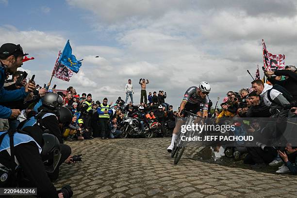Alpecin-Deceuninck's Dutch rider Mathieu van der Poel cycles in a breakaway leading the race at the Carrefour de l'Arbre, a cobblestone road, during...